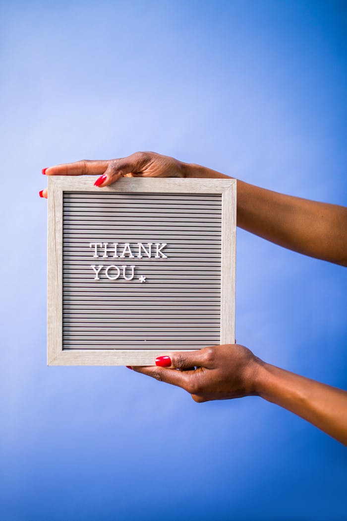 service-01 Hands holding thank you sign on blue backdrop, perfect for social media and digital marketing.