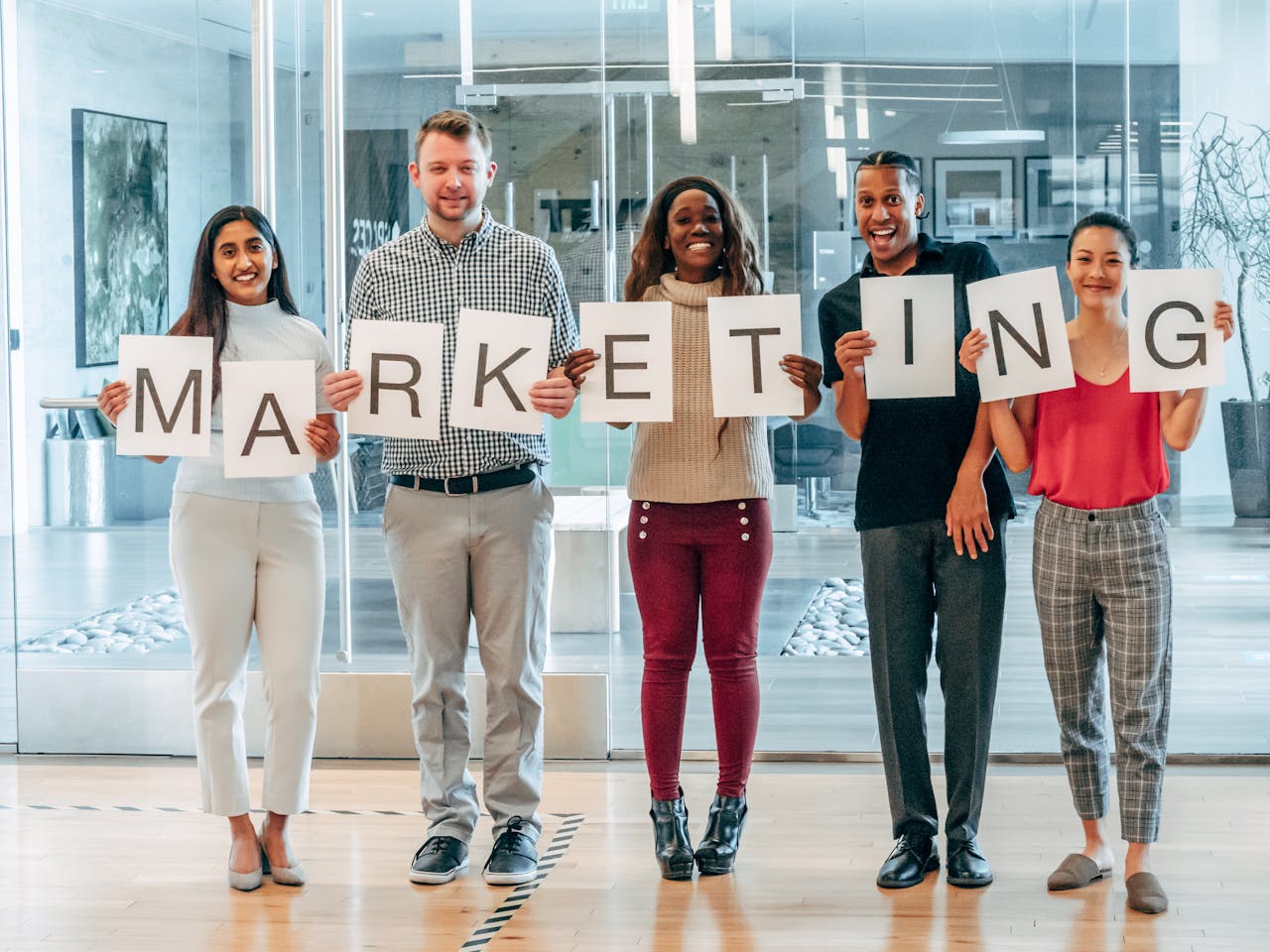 service-03 A diverse group of happy colleagues holding a marketing sign, symbolizing teamwork and diversity.